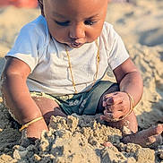 Aro a rejoint le concours — aidez-le/la à gagner de superbes lots ! baby, child, sand, beach, playing, gold_bracelet, gold_chain, white_shirt, shorts, sunlight, outdoor, summer, skin, head, hands, feet, closeup, portrait, nature, happy