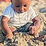 baby, child, sand, beach, playing, gold_bracelet, gold_chain, white_shirt, shorts, sunlight, outdoor, summer, skin, head, hands, feet, closeup, portrait, nature, happy