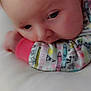 Nova is registered to the contest to win money with this photo: baby, child, face, pajamas, colorful_clothing, close_up, resting, soft_surface, indoor, infant, cute, calm, sleepwear, patterned_clothing, head, young_child, skin, expression, person, portrait