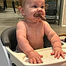 Lyra joined the competition — help win amazing prizes! baby, high_chair, food, messy, indoor, child, curly_hair, skin, hands, face, eating, kitchen, floor, furniture, plate, seat, person, expression, table, young