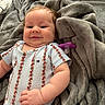 Lyra joined the competition — help win amazing prizes! baby, infant, smile, face, blanket, pacifier, clothing, floral_pattern, cute, soft_texture, lying_down, chubby_cheeks, indoors, cozy, comfort, portrait, skin, hand, expression, young_child