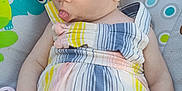 Alaya is registered to the contest to win money with this photo: arm, baby, baby_seat, child, circles, colorful, cute, expression, frog_design, hand, head, indoors, infant, patterned_background, romper, sitting, skin, striped_clothing, tongue_out, young_child