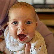 Lou a rejoint le concours — aidez-le/la à gagner de superbes lots ! baby, background_blur, big_eyes, caregiver_hand, cheeks, closeup, eyelashes, face, hand, happy, head, indoors, infant, keyboard, onesie, open_mouth, polka_dots, portrait, skin, smile