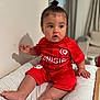Kaylan participe au concours pour gagner de l'argent avec cette photo : baby, child, infant, toddler, red_clothing, sportswear, tunisia, sitting, indoor, cushion, striped, top_knot, curious, face, foot, hand, expression, cute, young, person