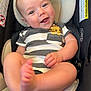 baby, infant, smiling, car_seat, striped_clothing, lion_graphic, cute, happy, child, person, sitting, foot, hand, head_support, indoor, skin, eyes, mouth, casual, comfort