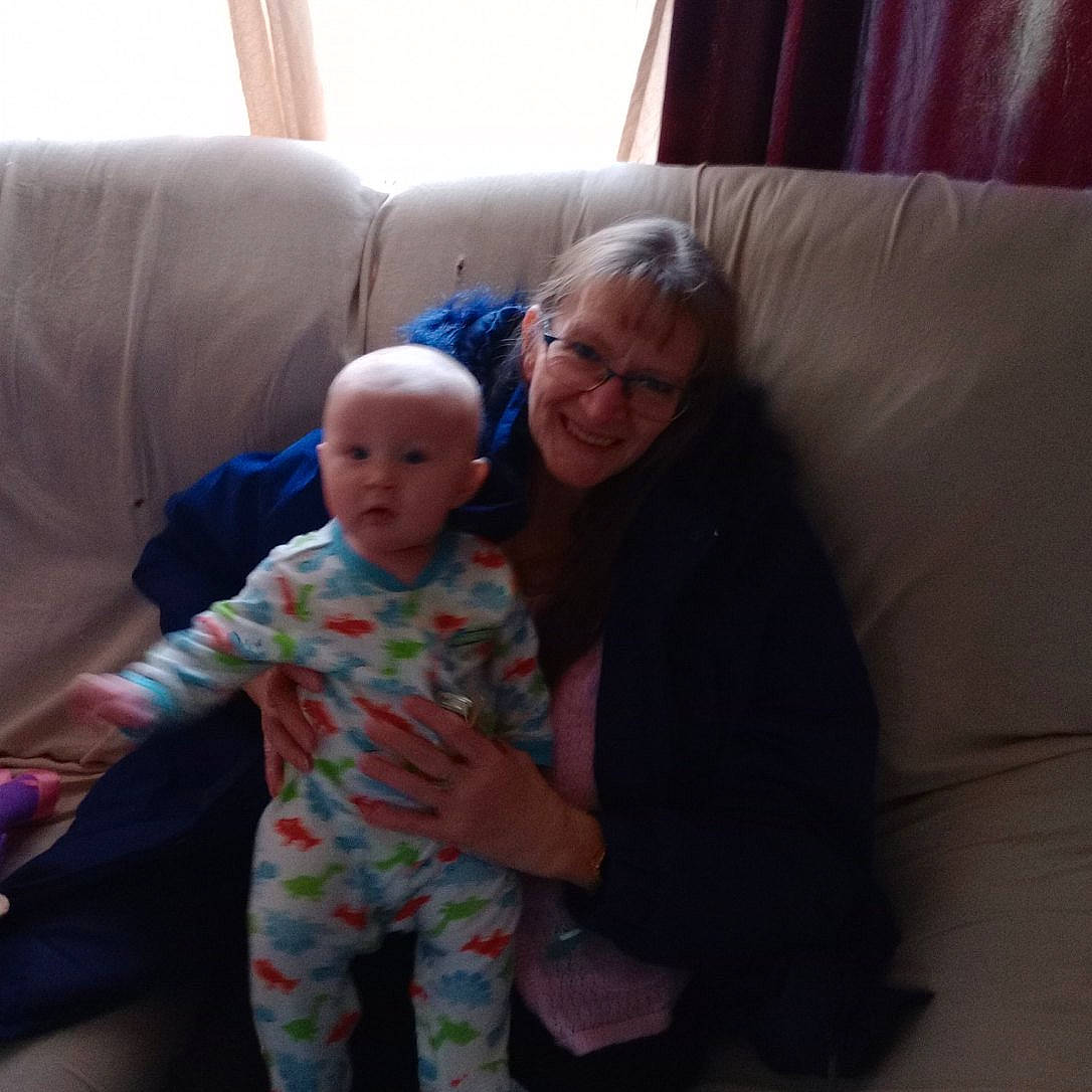 Kiera joined the competition — help win amazing prizes! baby, baby_toddler_clothing, child, comfort, couch, curtain, event, face, flooring, fun, happy, head, human_body, joy, lap, living_room, pajamas, person, room, sitting