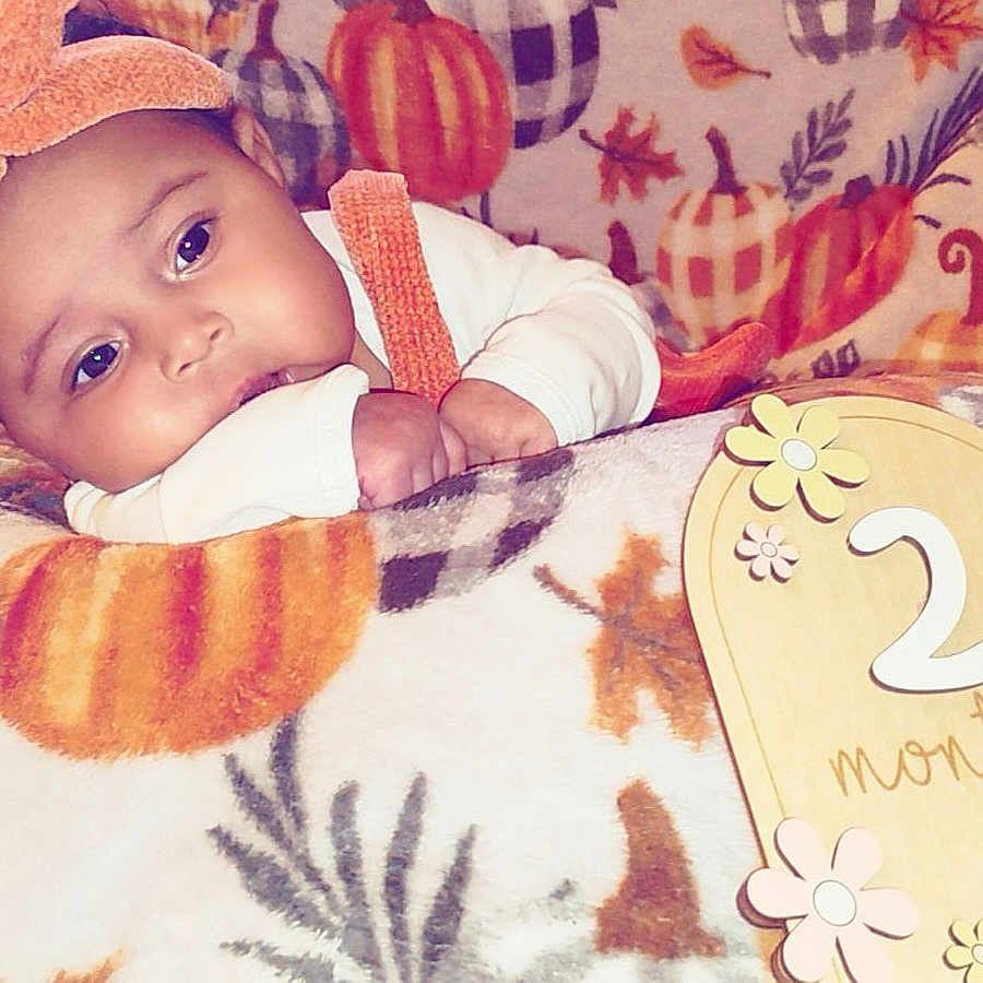 Llovae is registered to the contest to win money with this photo: baby, bed, blanket, bonnet, cap, clothing, cushion, face, furniture, hat, head, homedecor, newborn, number, person, photography, portrait, quilt, symbol, text