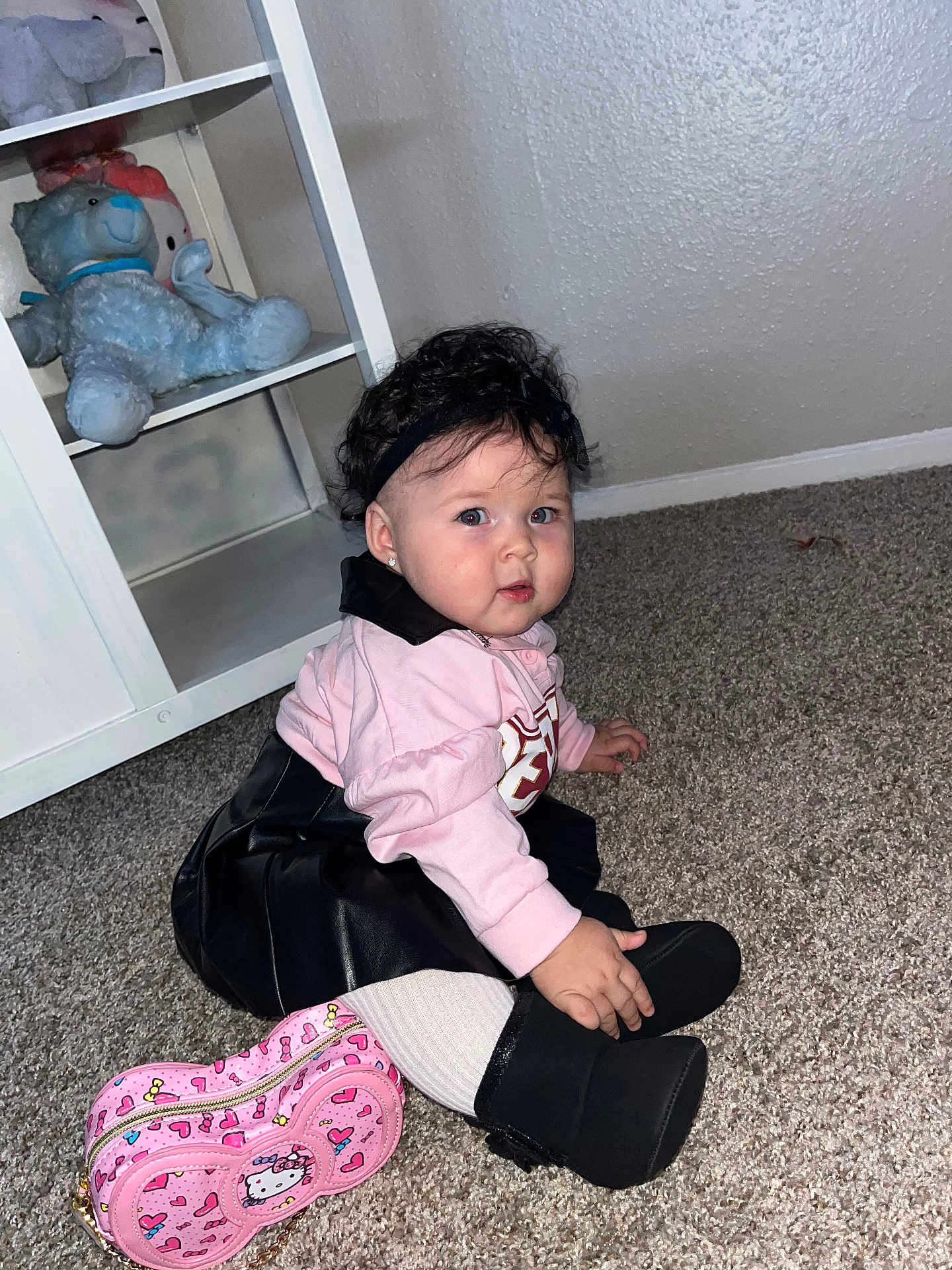 Daphne Zeinet joined the competition — help win amazing prizes! toddler, child, curly_hair, headband, pink_top, black_skirt, white_tights, black_boots, hello_kitty_purse, carpet, sitting, indoor, stuffed_animals, shelf, toy, cute, portrait, floor, young_child, fashion
