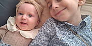 Soline a rejoint le concours — aidez-le/la à gagner de superbes lots ! baby, blanket, candid, child, closeup, couch, cute, face, family, happy, headband, indoor, joyful, patterned_shirt, person, portrait, sibling, smile, toddler, young
