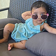 Sadhana joined the competition — help win amazing prizes! baby, child, sunglasses, blue_clothing, polka_dot, cushion, chair, outdoor, relaxed, cute, infant, person, fashion, seat, summer, shade, expression, skin, foot, hand