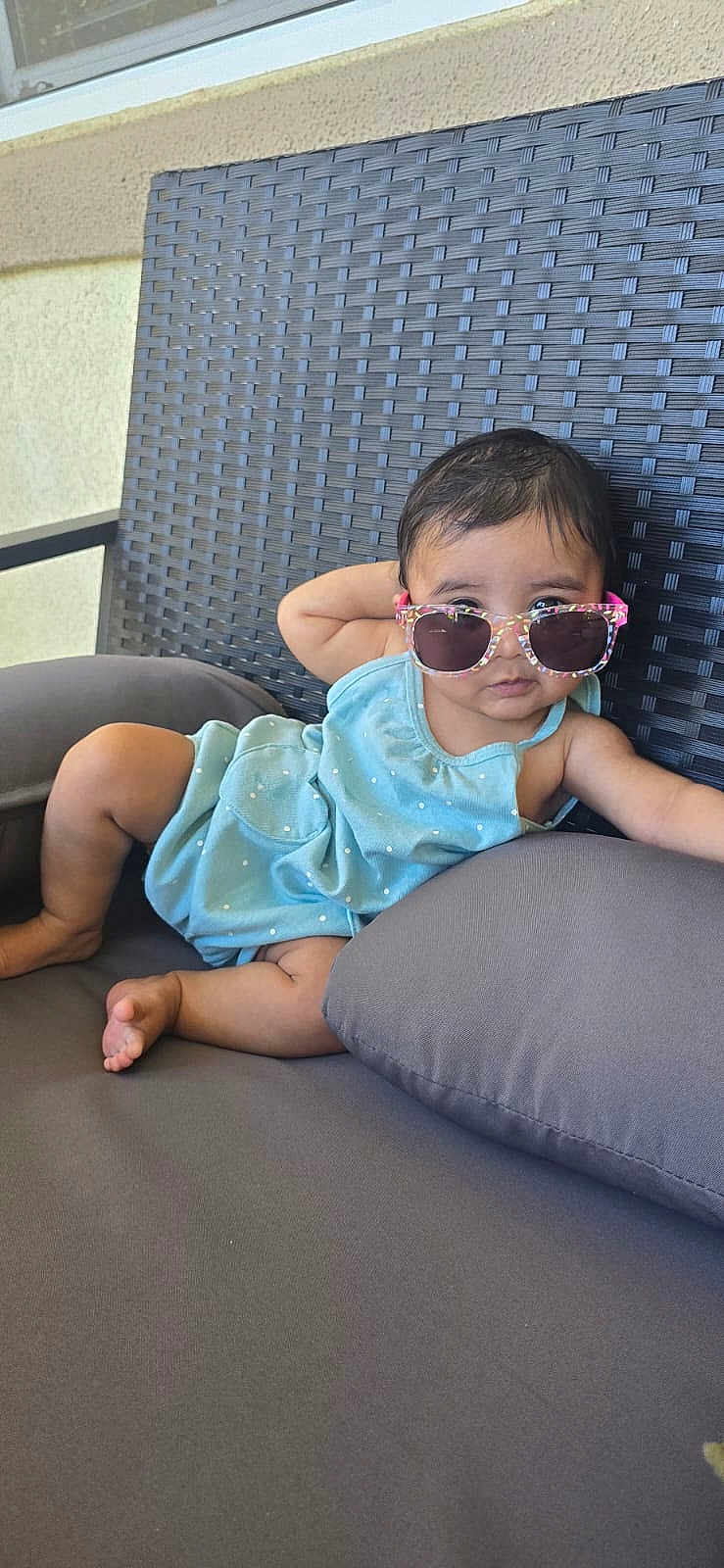 Sadhana joined the competition — help win amazing prizes! baby, child, sunglasses, blue_clothing, polka_dot, cushion, chair, outdoor, relaxed, cute, infant, person, fashion, seat, summer, shade, expression, skin, foot, hand