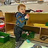 Jason joined the competition — help win amazing prizes! toddler, child, toy, playroom, carpet, cd, light_table, sweatshirt, hoodie, sneakers, furniture, fan, indoor, smiling, person, green, plastic_toy, shelf, floor, happy