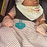 adorable, baby, bib, blanket, car_seat, child, cute, hat, indoors, infant, mittens, pacifier, peaceful, pink_clothing, portrait, resting, seatbelt, sleeping, soft_lighting, striped_blanket