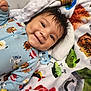 River is registered to the contest to win money with this photo: baby, smiling, blanket, pacifier, cute, infant, clothing, face, happy, lying_down, soft_texture, child, indoors, playful, colorful, warm, comfort, expression, hair, portrait