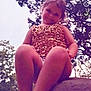 child, girl, outdoor, nature, trees, sky, rock, smiling, sitting, sparkly_clothing, gold, barefoot, portrait, young, casual, daylight, happy, cute, playful, fun