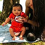 Zaqurian is registered to the contest to win money with this photo: baby, child, woman, outdoor, tree, blanket, grass, red_clothing, long_hair, smiling, holding, nature, sunlight, person, casual, sitting, happy, face, portrait, family