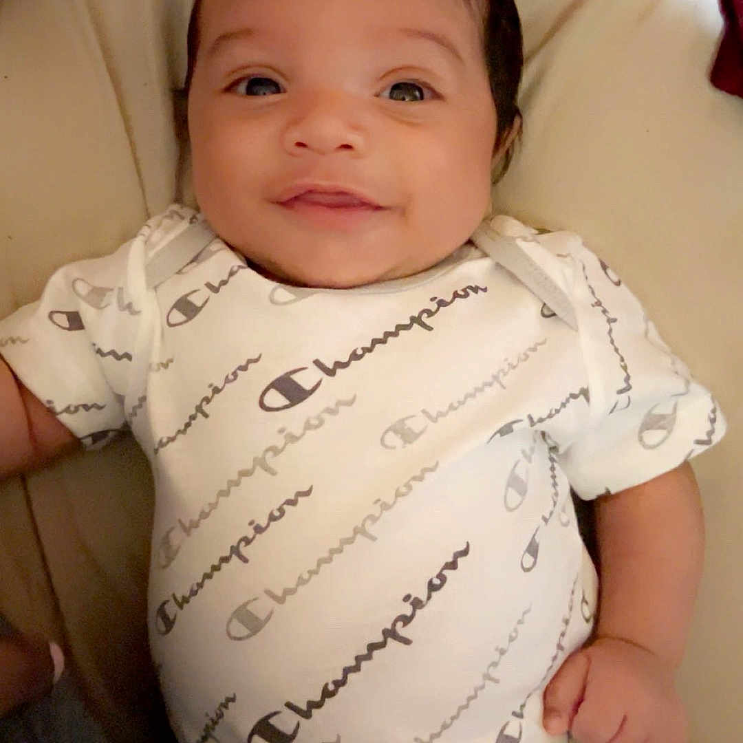 Zaqurian joined the competition — help win amazing prizes! baby, bed, casual, child, clothing, comfort, cute, fabric, face, hand, happy, indoor, infant, lying_down, newborn, onesie, person, portrait, skin, smiling