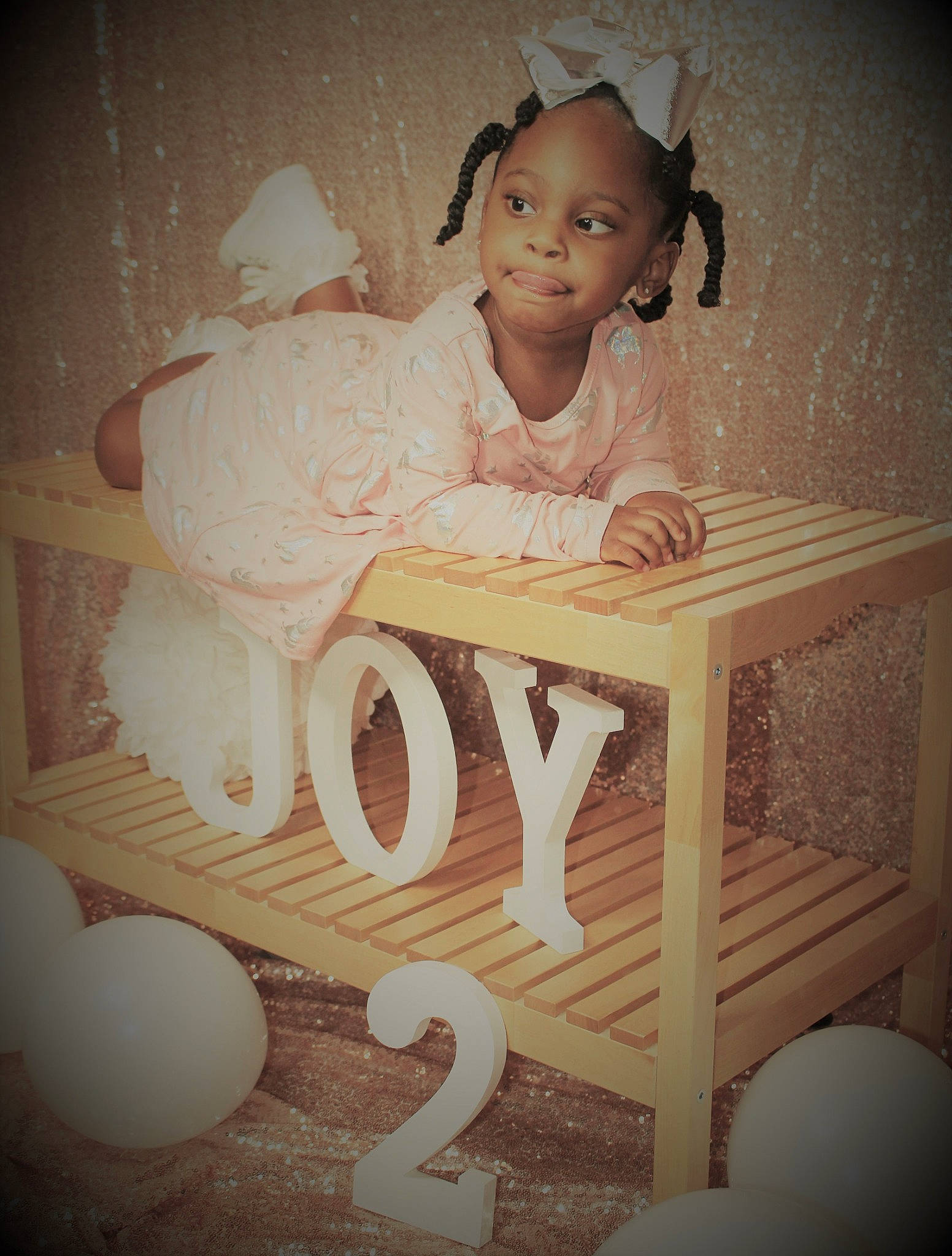 Joy is registered to the contest to win money with this photo: arm, art, baby, baby_toddler_clothing, chair, comfort, dress, face, flash_photography, floor, flooring, happy, hardwood, headpiece, human_body, joy, person, room, sitting, table