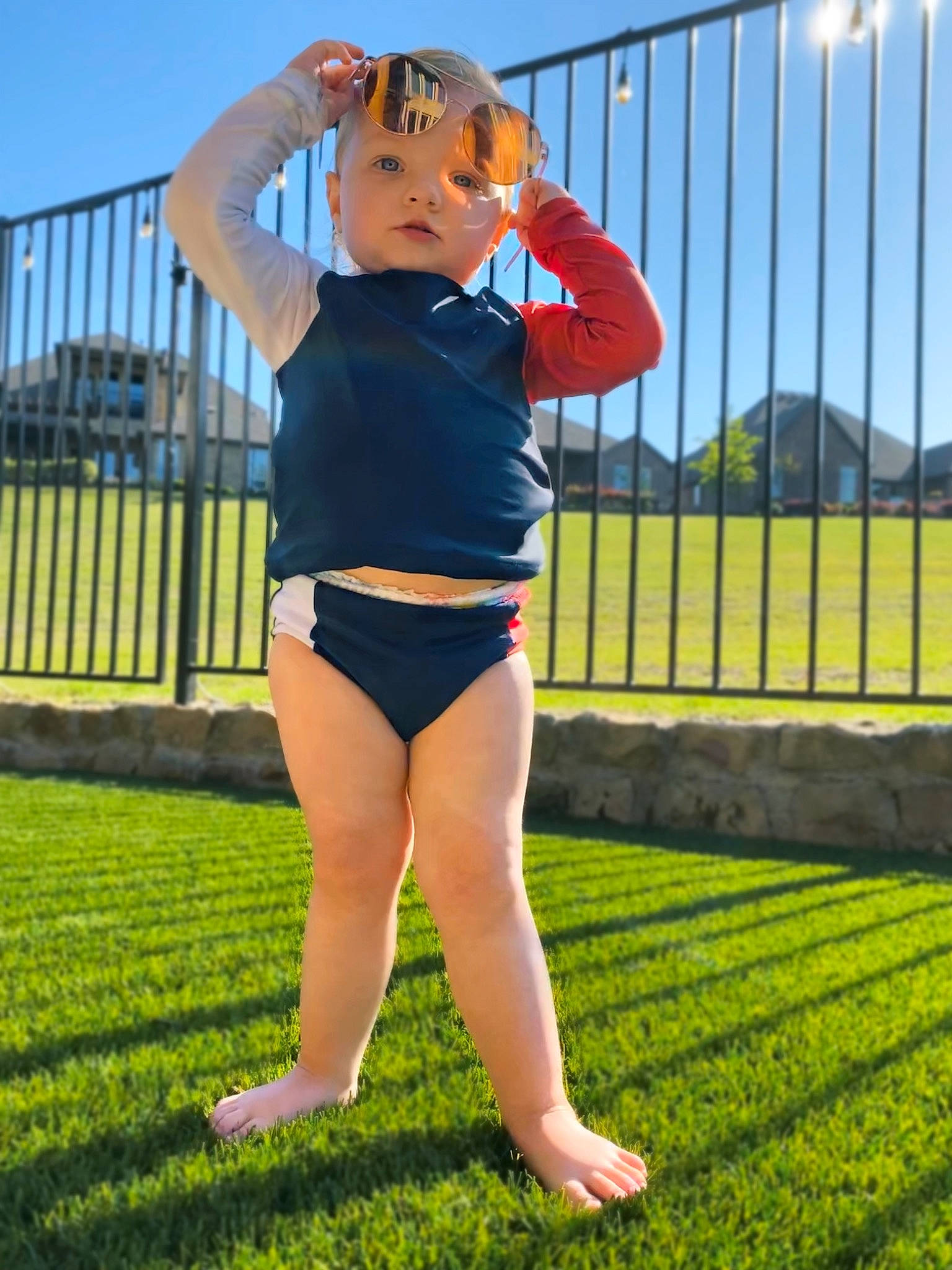 Harleigh is registered to the contest to win money with this photo: barefoot, child, clothing, grass, headwear, lawn, leg, person, photography, plant, sportswear, summer, thigh, vacation