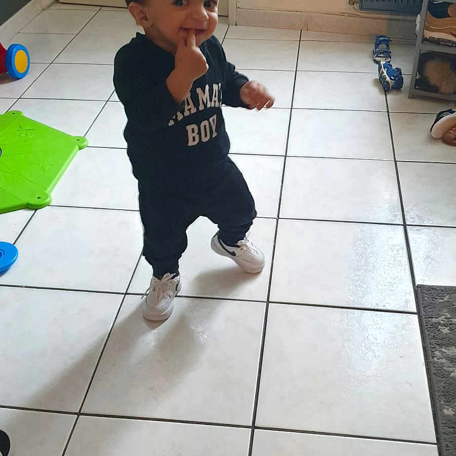 Yanis participe au concours pour gagner de l'argent avec cette photo : bodypart, boy, child, clothing, face, footwear, head, jeans, male, mouth, pants, person, photography, plant, portrait, pottedplant, shoe, t_shirt, teeth, tile
