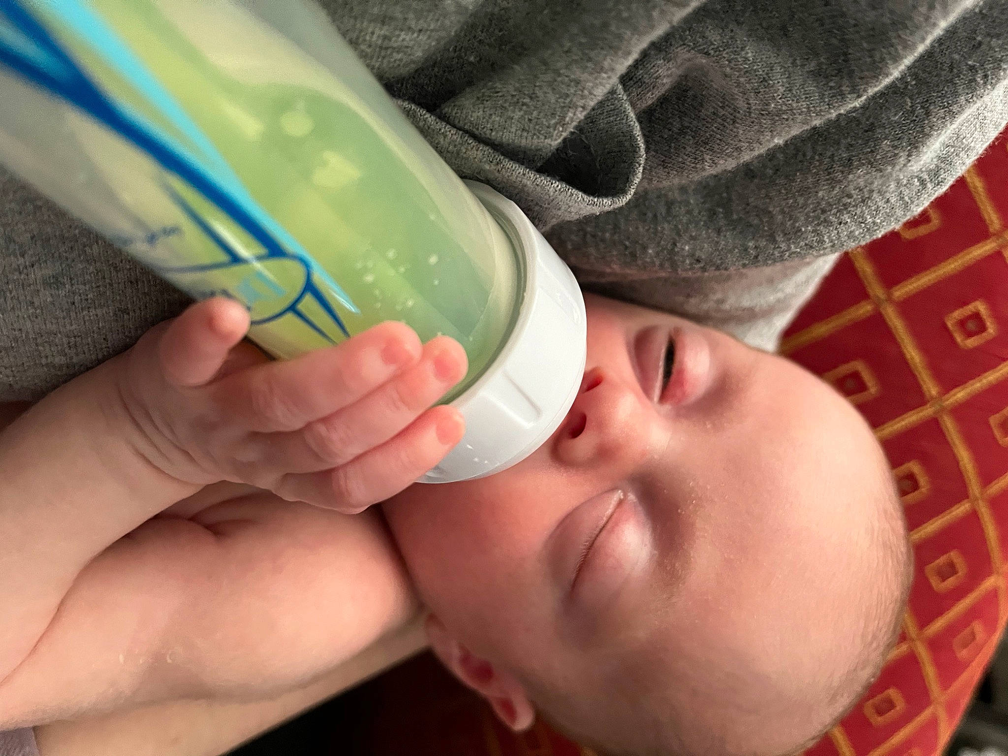Bliss is registered to the contest to win money with this photo: baby, baby_bottle, bottle, child, comfort, drinkware, ear, eyelash, finger, gesture, hand, human_body, leg, nail, person, plastic_bottle, skin, tableware, thumb, water