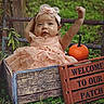 baby, child, outdoor, pumpkin, crate, dress, headband, wooden_sign, greenery, grass, fall, autumn, cute, smiling, nature, celebration, portrait, person, happy, seasonal