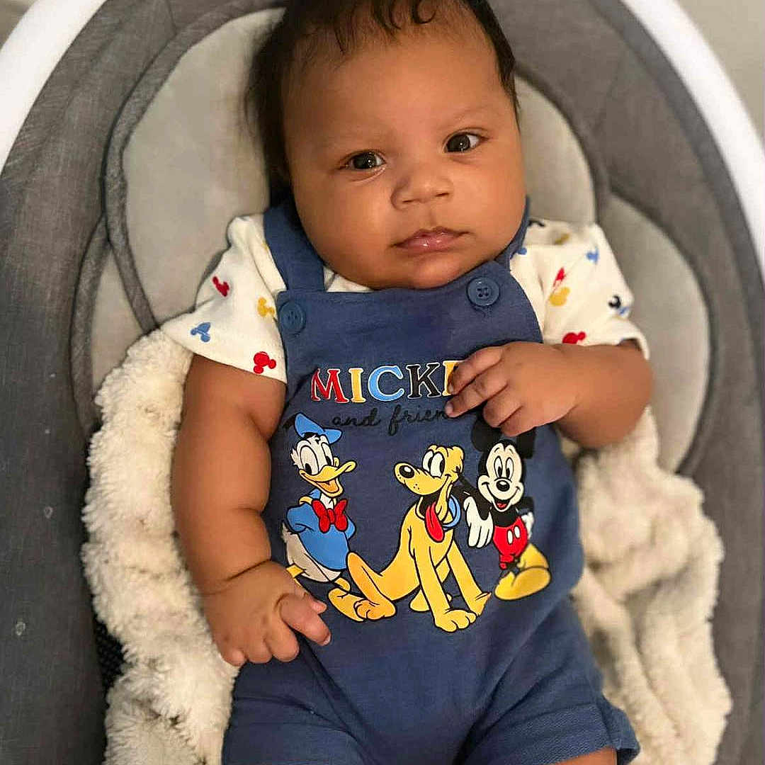 Yo'Shon is registered to the contest to win money with this photo: baby, baby_boy, baby_seat, blanket, blue_outfit, child, clothing, cozy, cute, donald_duck, indoor, infant, mickey_mouse, person, pluto, portrait, sitting, smiling, soft_lighting, young_child