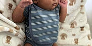 Yo'Shon is registered to the contest to win money with this photo: baby, infant, blanket, teddy_bear_pattern, blue_onesie, striped_clothing, newborn, soft_texture, cute, lying_down, small_fists, curly_hair, skin, child, indoors, cozy, portrait, adorable, resting, sleepwear