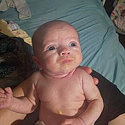 Aubree joined the competition — help win amazing prizes! baby, infant, messy_face, diaper, bare_chest, person, hand, bed, blanket, bottle, indoor, curious, skin, blue_eyes, adult_hand, holding, rumpled_bed, casual, caregiver, newborn