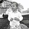 child, boy, easter_basket, outdoor, black_and_white, log, grass, shirt, pants, portrait, cute, holiday, spring, nature, face, smiling, young, holding, background, daylight