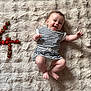 baby, barefoot, celebration, child, cute, fluffy_rug, fruit, happy, indoors, infant, lying_down, number_four, playful, portrait, skin, smiling, soft_texture, strawberries, striped_clothing, young