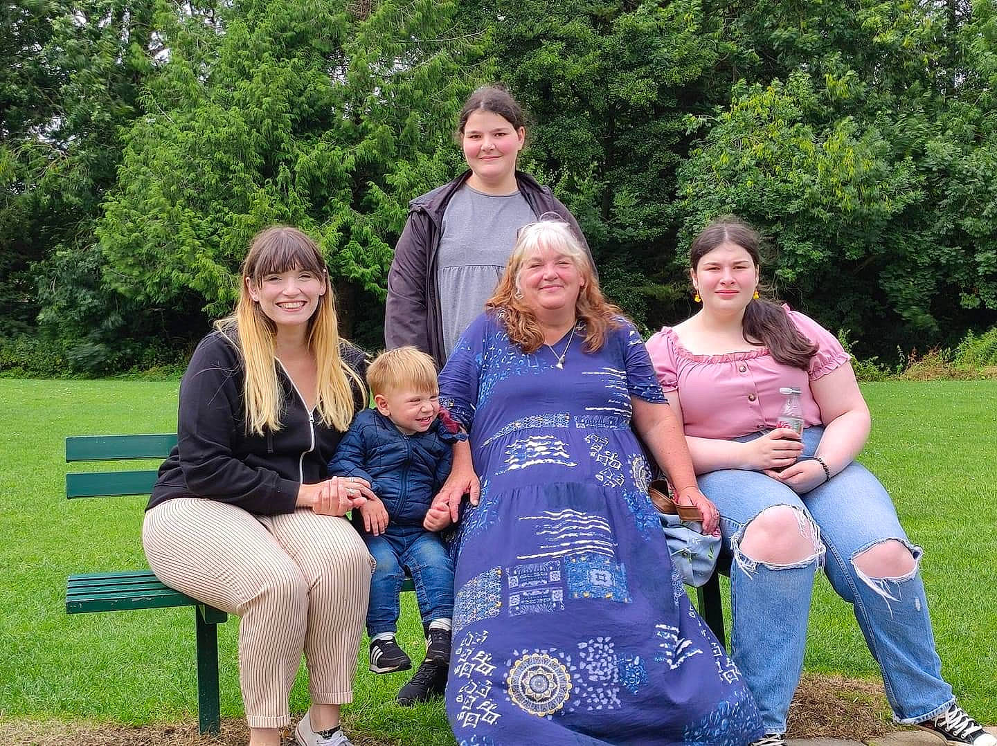 Billy is registered to the contest to win money with this photo: boot, botany, event, face, footwear, fun, grass, green, happy, joy, lap, leg, leisure, luggage_and_bags, people_in_nature, person, plant, shoe, smile, sneakers