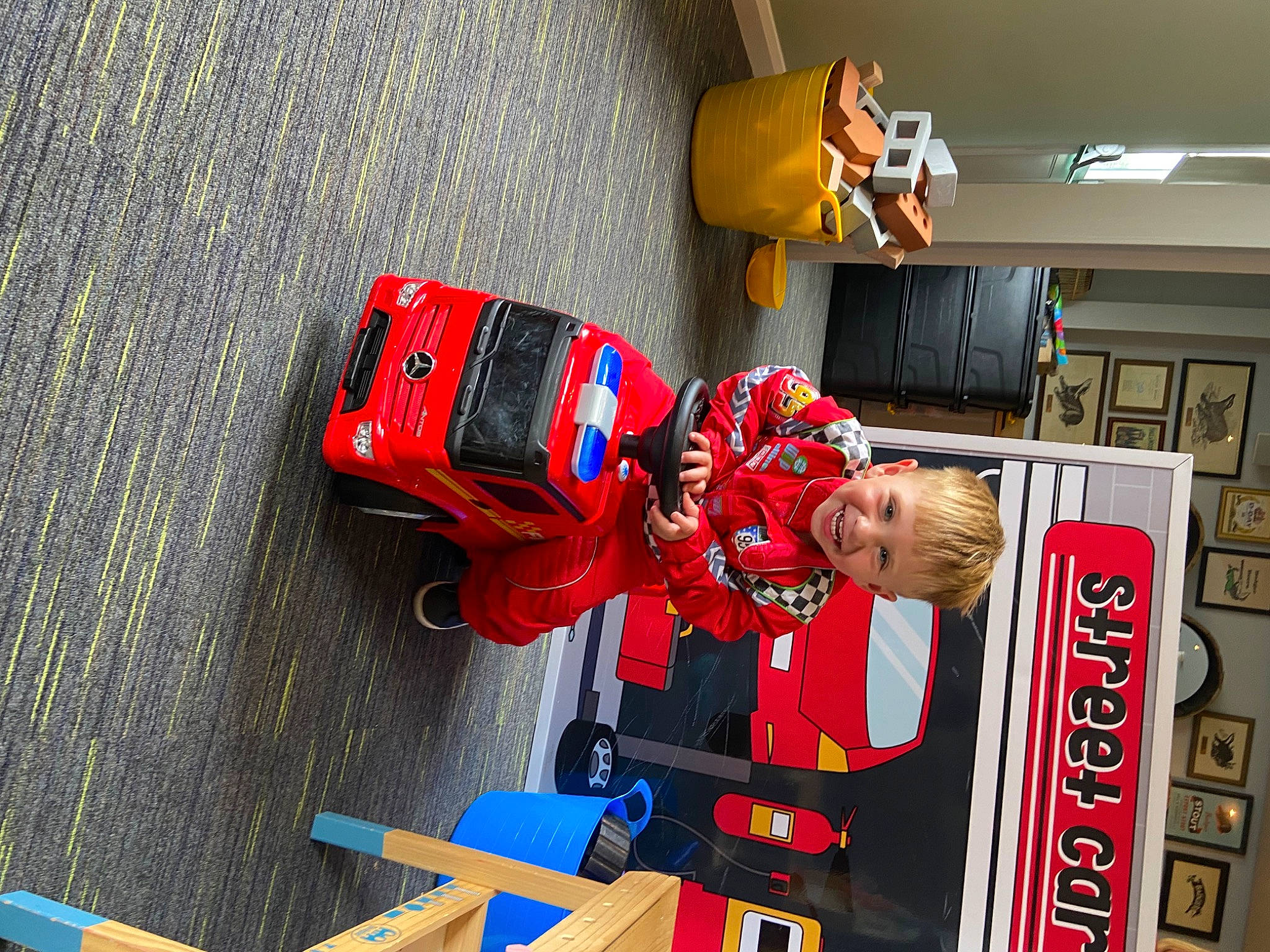 Billy is registered to the contest to win money with this photo: asphalt, carmine, engineering, fictional_character, fun, joy, machine, person, personal_protective_equipment, recreation, toddler, yellow