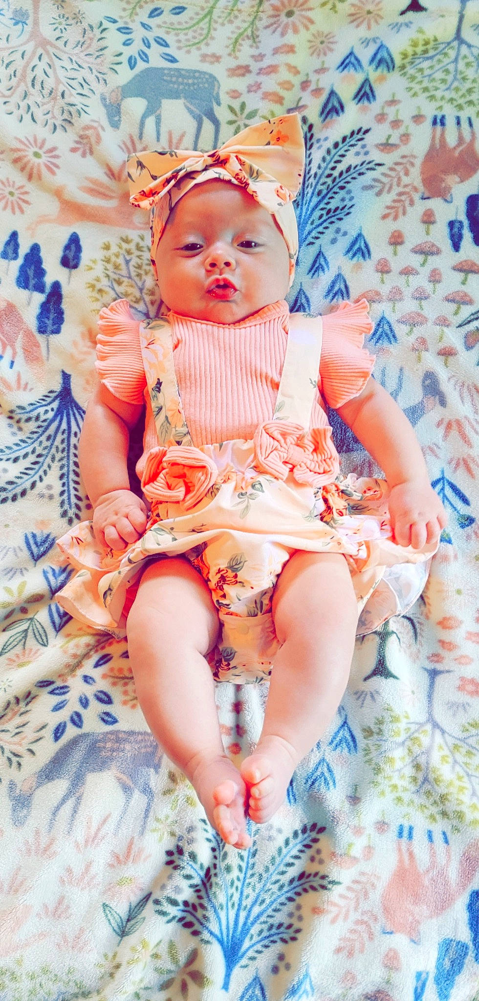 Gianna is registered to the contest to win money with this photo: baby, baby_toddler_clothing, blue, chair, cheek, child, dress, fashion_design, finger, head, headwear, human_leg, mouth, orange, pattern, peach, person, pink, sitting, skin