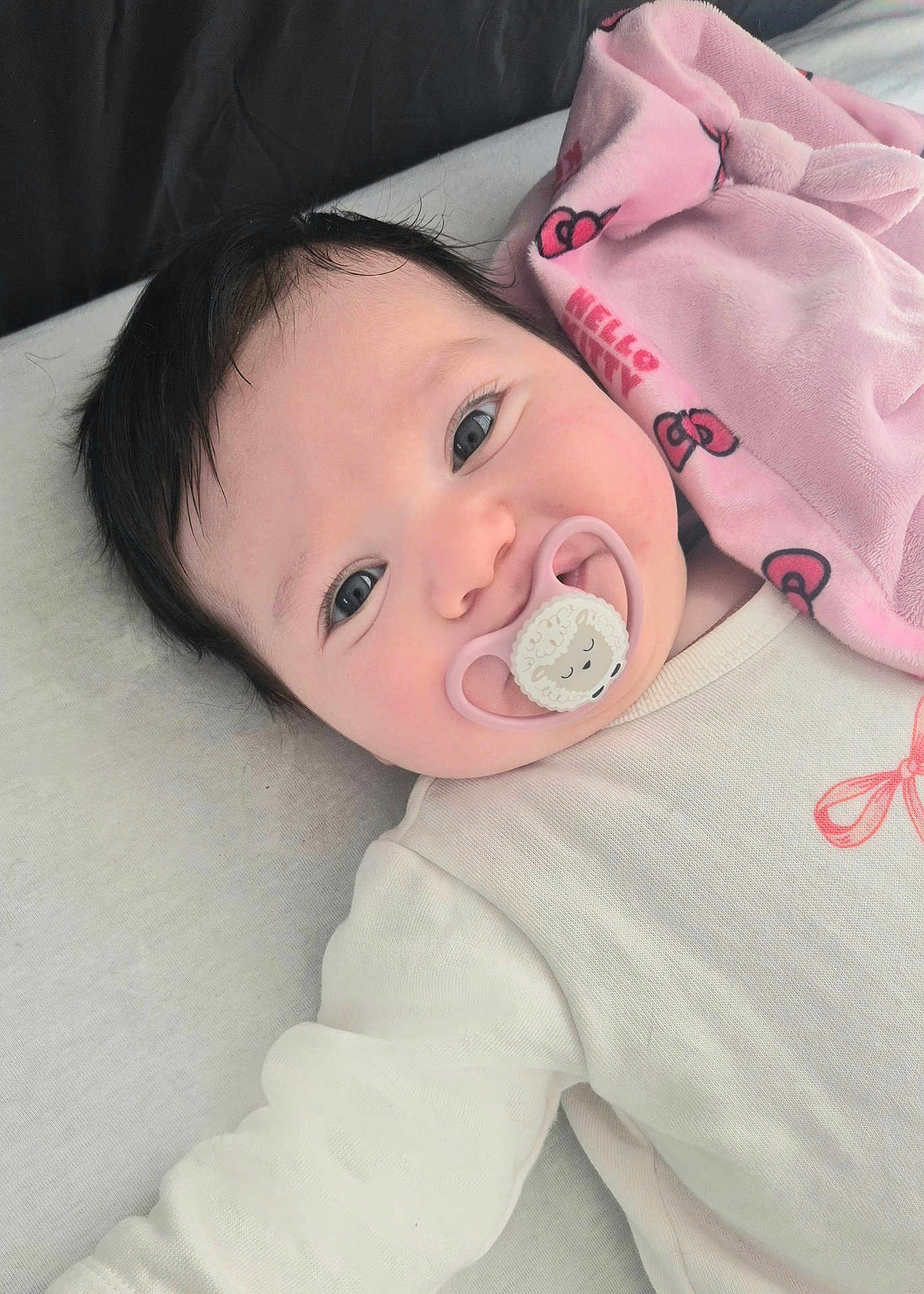 Justine a rejoint le concours — aidez-le/la à gagner de superbes lots ! baby, infant, pacifier, blanket, pink, onesie, smiling, face, eyes, hair, closeup, cute, newborn, cozy, soft, lying_down, bed, cheek, portrait, child