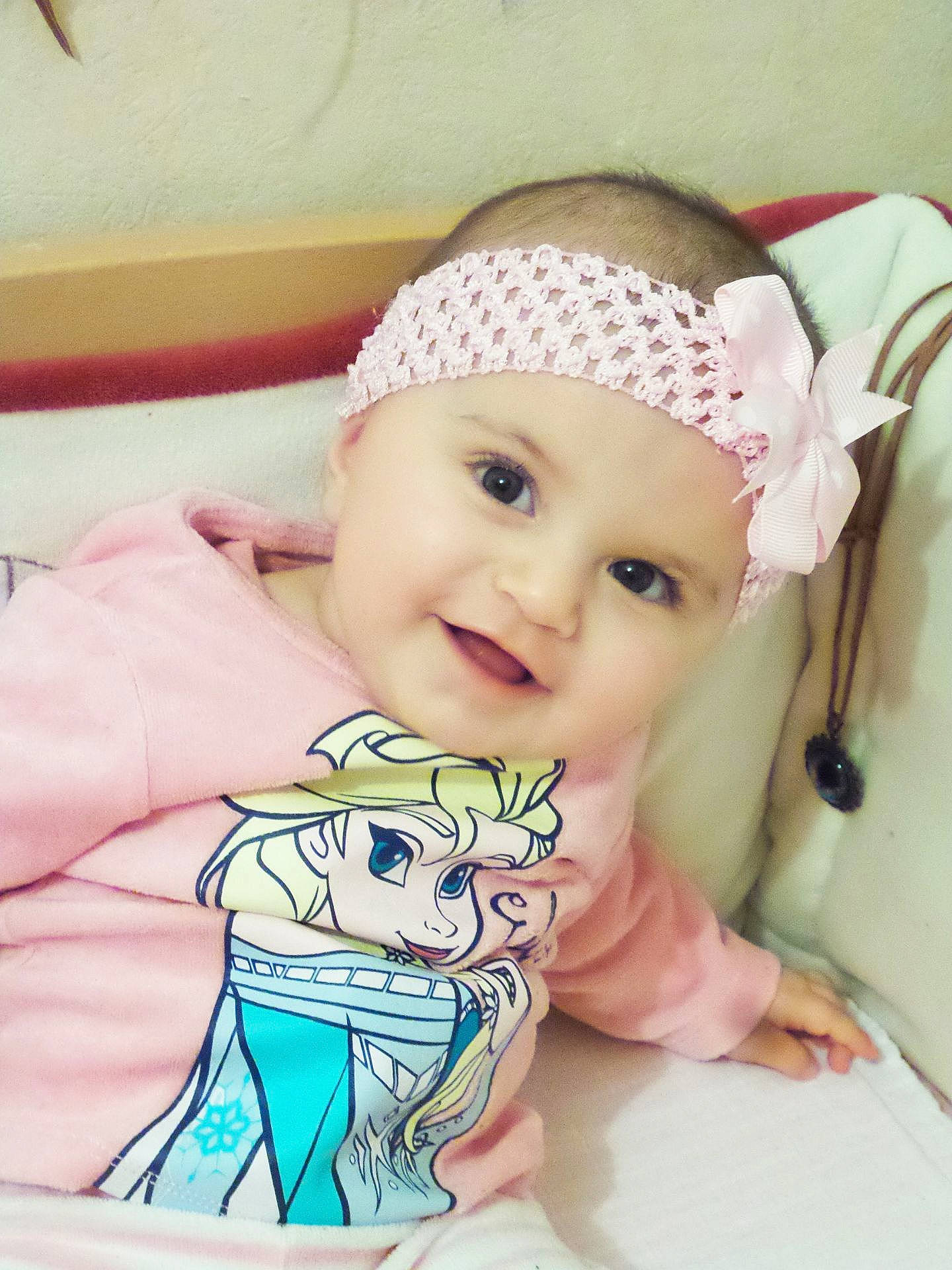 Amélie participe au concours pour gagner de l'argent avec cette photo : cheek, child, ear, eye, girl, hair_accessory, head, headband, headgear, infant, person, pink, product, skin, smile, textile, toddler