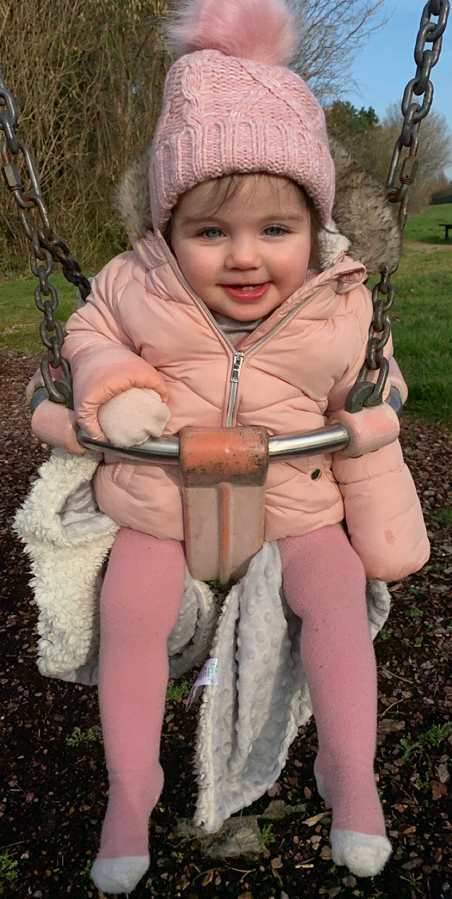 Lexie is registered to the contest to win money with this photo: child, fur, headwear, joy, person, sitting, smile, swing, toddler, tree