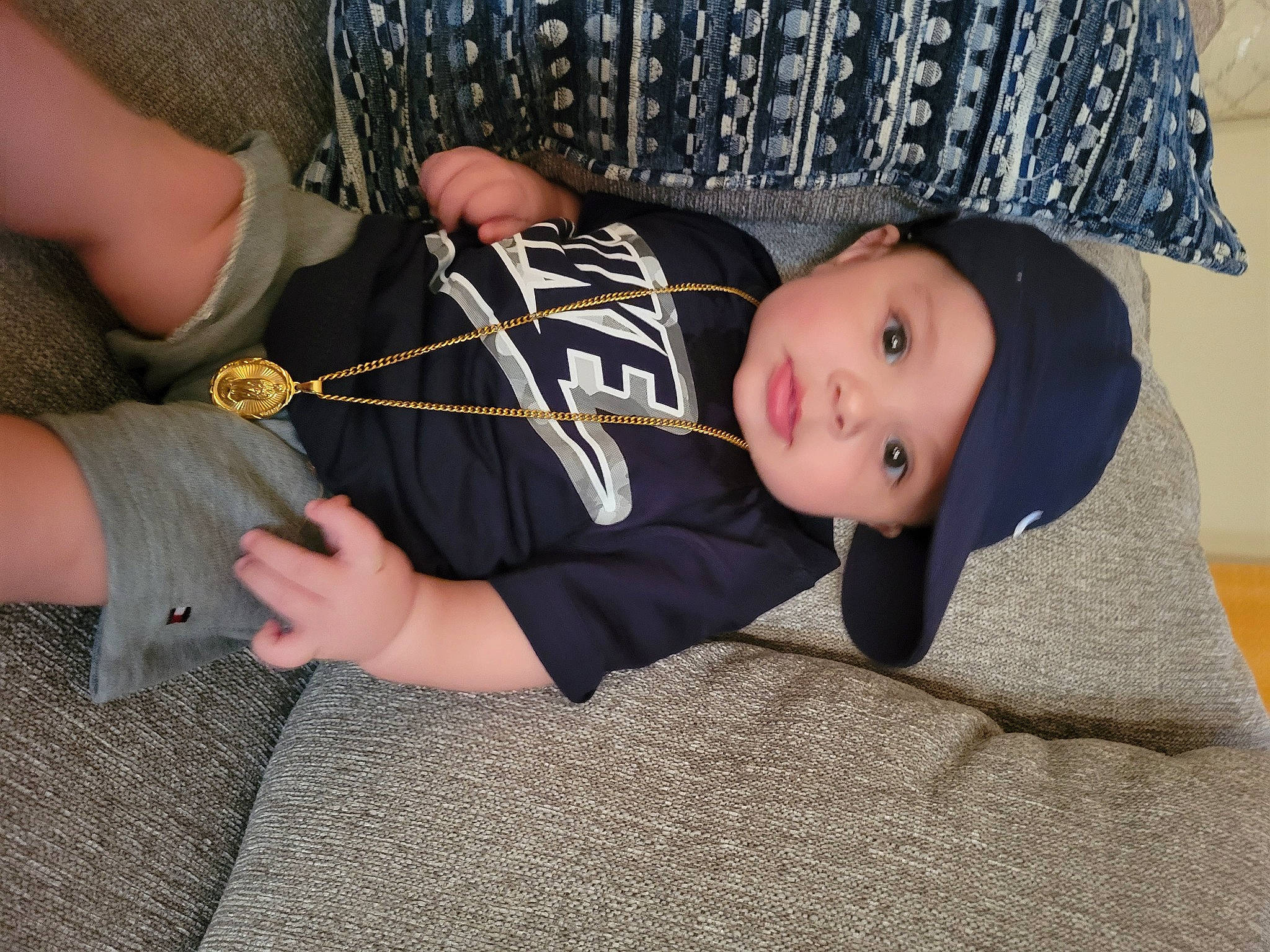 Chandler Drum joined the competition — help win amazing prizes! baby, baby_toddler_clothing, comfort, eye, gesture, grass, hat, head, headwear, human_leg, knee, leg, pattern, person, sitting, sleeve, sun_hat, thigh, thumb, toddler