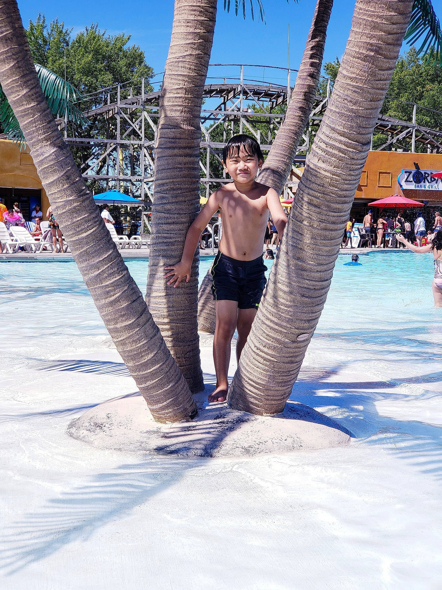 Damian is registered to the contest to win money with this photo: arecales, barechested, beach, fun, jeans, leg, leisure, palm_tree, person, plant, shorts, smile, spring_break, summer, tourism, tree, tropics, vacation, water, water_park