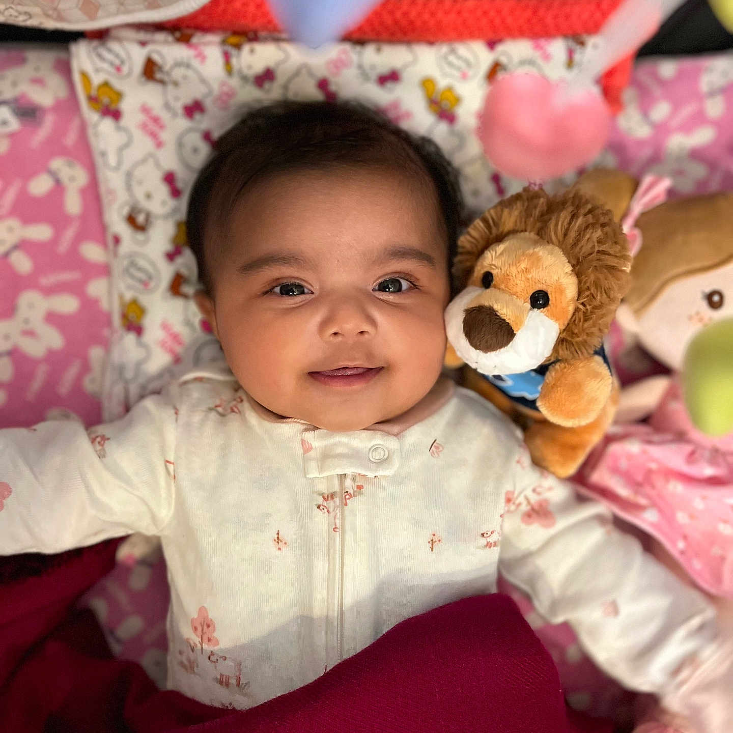 Navya joined the competition — help win amazing prizes! baby, baby_clothes, blanket, child, cute, doll, face, happy, indoors, infant, lion, lying_down, nursery, pink, plush_toy, portrait, smiling, soft_toy, toy, white_clothing