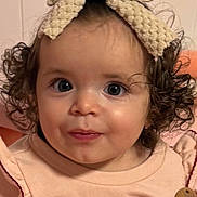 Elizabeth is registered to the contest to win money with this photo: child, baby, toddler, face, big_eyes, curly_hair, headband, bow, pink_clothing, strawberry_embroidery, wooden_button, ruffle_sleeves, portrait, close_up, indoor, wall_paneling, cheeks, smile, adorable, nose
