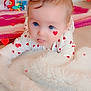 baby, infant, heart_pattern, blanket, floor, toy, blue_eyes, tongue_out, cute, indoors, child, soft_texture, fluffy_blanket, pink, red, white, playful, lying_down, warm_lighting, decor