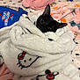 Duchess is registered to the contest to win money with this photo: black_cat, blanket, hello_kitty, bed, pillow, plush, cozy, wrapped, looking_up, whiskers, big_eyes, fur, textile_pattern, soft, cute, indoor, bedroom, toy_print, bedding, portrait