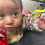 Lucian joined the competition — help win amazing prizes! baby, blanket, child, close_up, couch, cozy, curious, expression, eyes, face, fuzzy_jacket, hand, home, indoor, infant, red, skin, soft, toy, warm