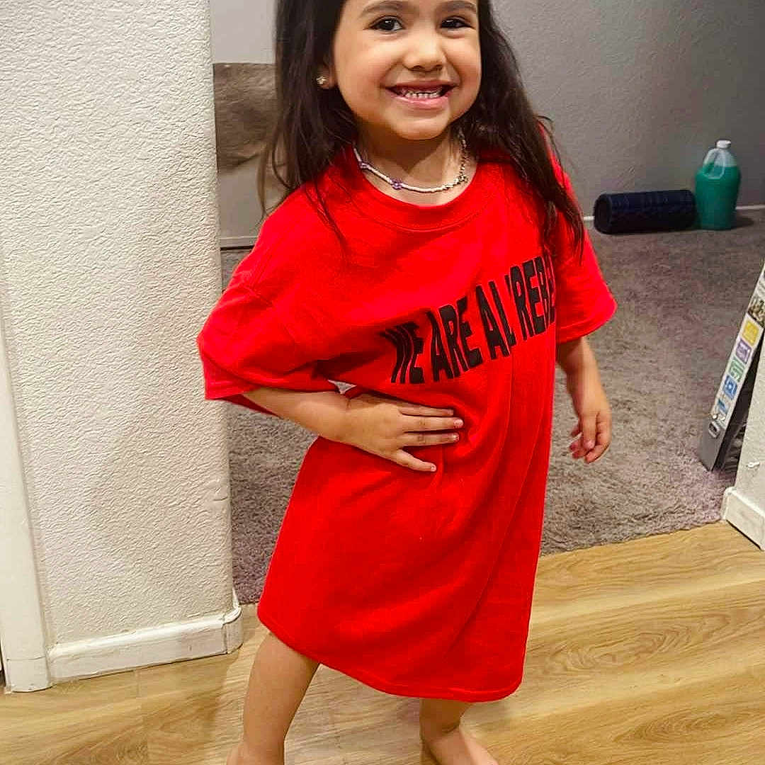 Alayna is registered to the contest to win money with this photo: accessories, child, clothing, door, dress, face, female, girl, hair, hardwood, head, jewelry, necklace, person, photography, portrait, sleeve, standing, t_shirt, wood