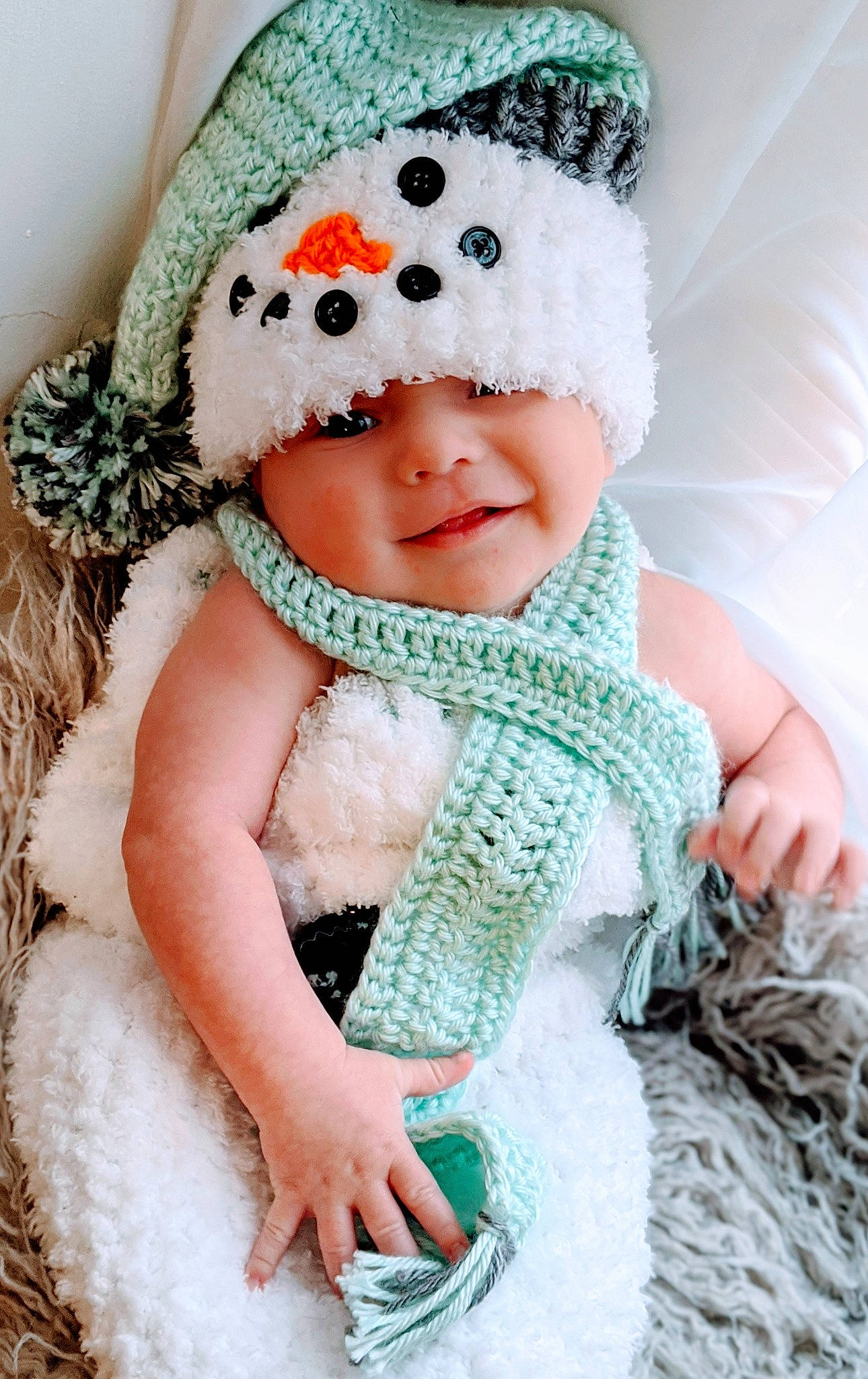Ty. is registered to the contest to win money with this photo: art, baby, beanie, cap, child, costume_accessory, crochet, green, hat, headgear, headwear, knit_cap, outerwear, pattern, person, snowman, toddler, winter, wool