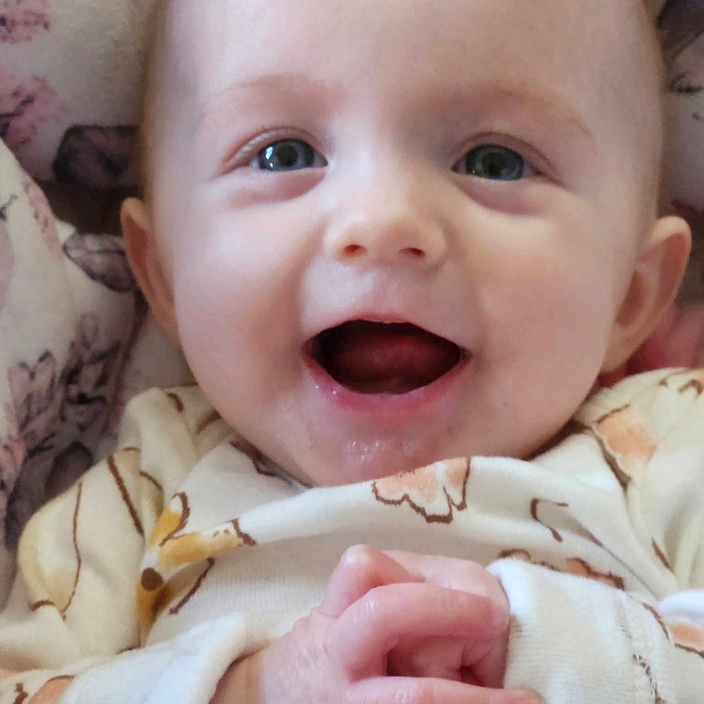 Mikhayla is registered to the contest to win money with this photo: baby, blanket, blue_eyes, child, closeup, clothing, cozy, cute, expression, face, hands, happy, indoors, infant, newborn, onesie, pattern, portrait, skin, smiling