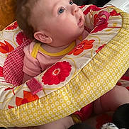 Roselee joined the competition — help win amazing prizes! baby, infant, child, portrait, wide_eyed, blue_eyes, smiling, sitting, bouncer, baby_seat, floral_pattern, blanket, pink_clothing, yellow, red, indoor, home, cozy, close_up, face