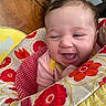 Roselee joined the competition — help win amazing prizes! baby, child, infant, smiling, laughing, winking, portrait, face, eyes, tongue, sitting, cushion, blanket, floral_pattern, colorful, indoor, home, furniture, happy, close_up