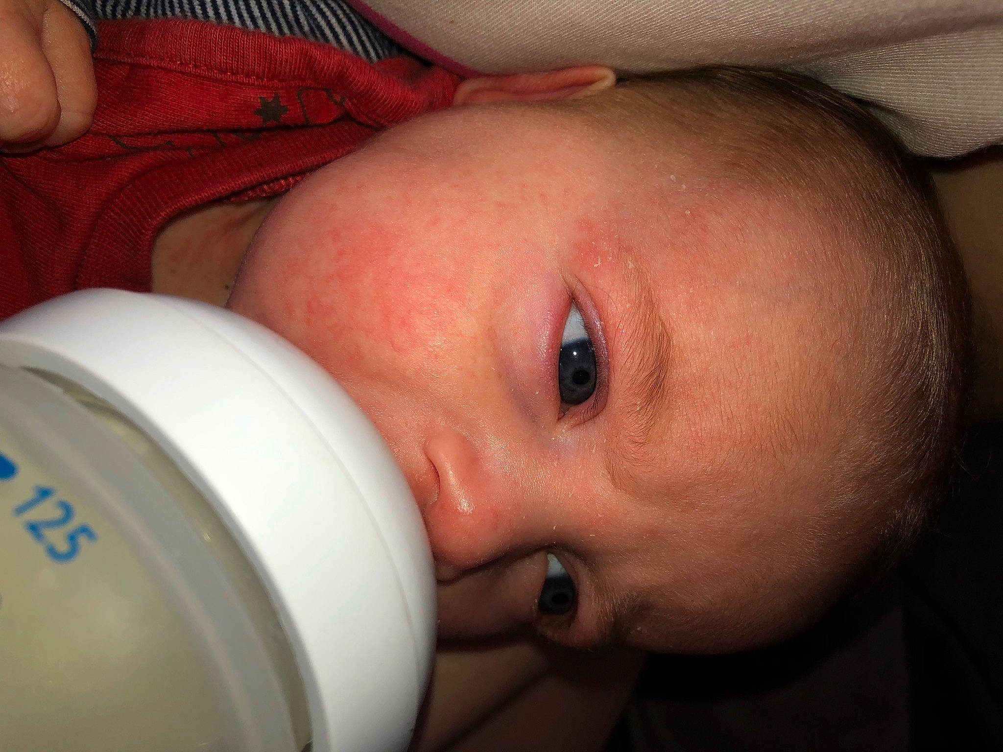 Maëlya a rejoint le concours — aidez-le/la à gagner de superbes lots ! baby, baby_bottle, bottle, cheek, drinkware, ear, eye, eyebrow, eyelash, finger, hand, human_body, infant_formula, iris, lip, mouth, nose, person, plastic_bottle, skin